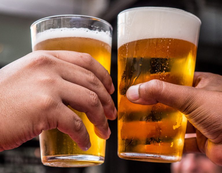 two hands cheers a pint of lagunitas beer in petaluma.