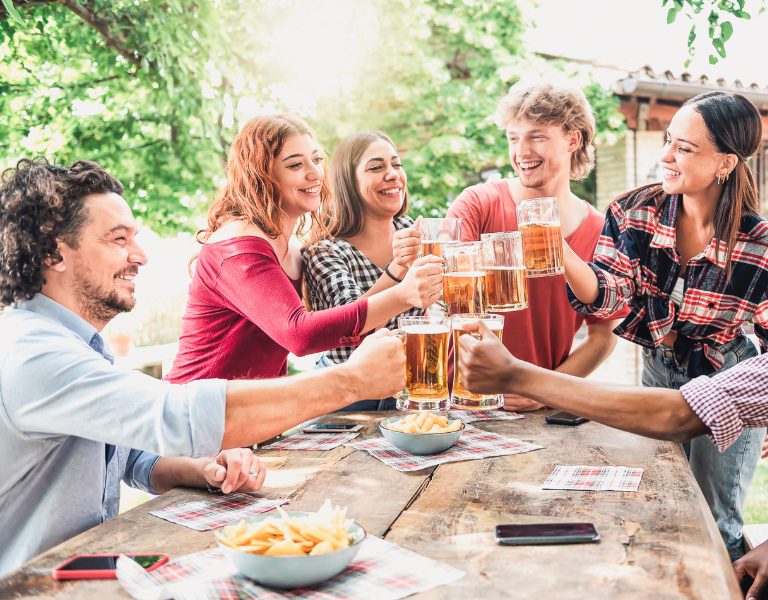 a group of people cheers beer pints while touring sonoma county breweries.