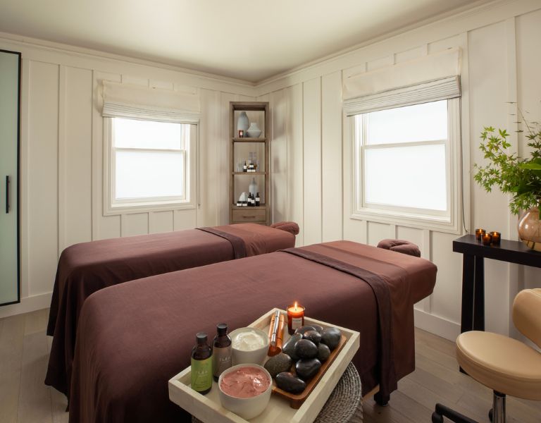 couples massage tables sit side by side draped in burgundy sheets