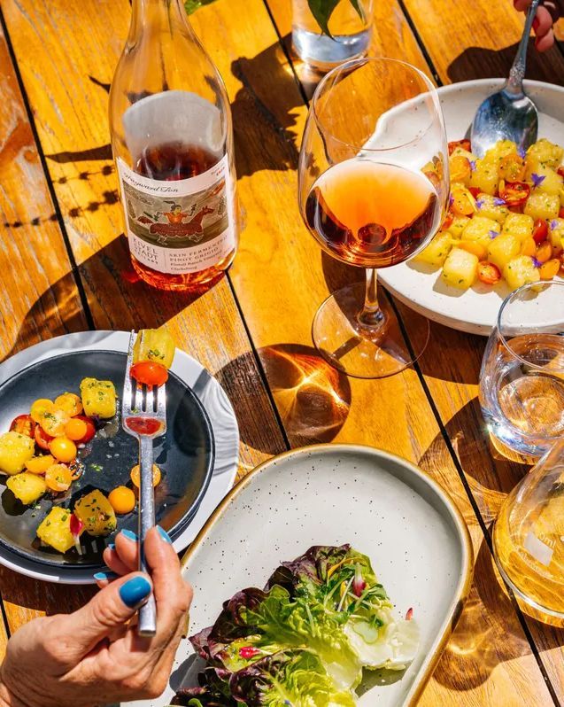 colorful plates of food and glasses of wine